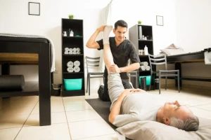 Fisioterapista con divisa no stiro esegue esercizi con un paziente